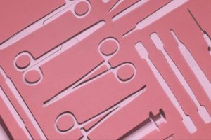 Surgical tools laid on pink background