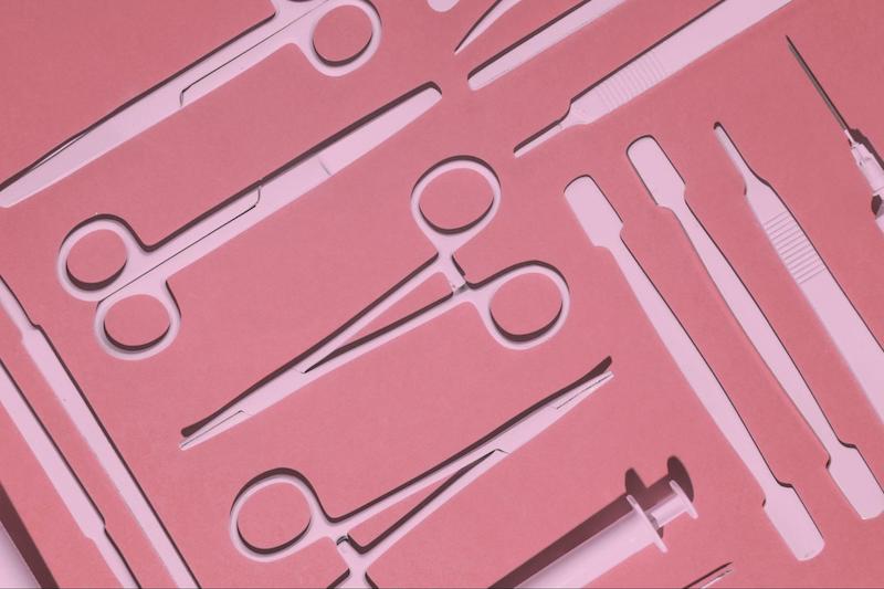 Surgical tools laid on pink background