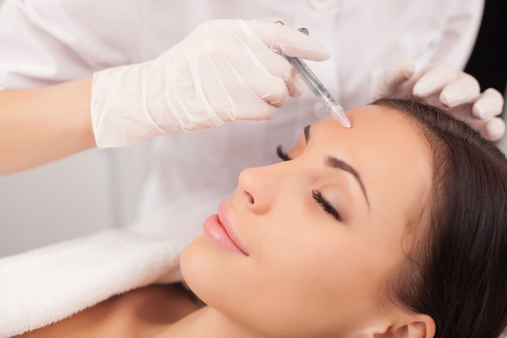 Woman getting Botox injected into her forehead